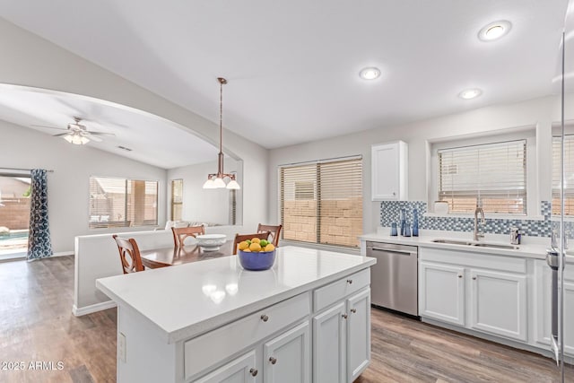 44853 W Jack Rabbit Trl, Maricopa, AZ 85139 - kitchen featuring dishwasher, vaulted ceiling, decorative backsplash, open floor plan, and light countertops
