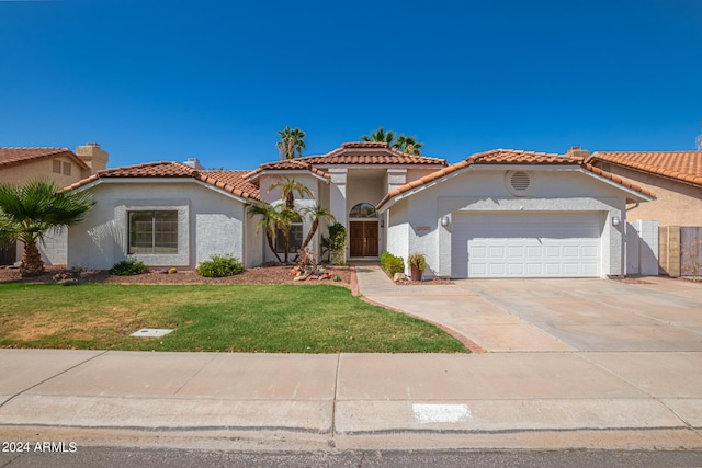 mediterranean / spanish-style house with a front lawn and a garage