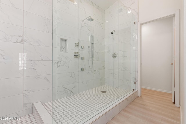 bathroom with hardwood / wood-style flooring and tiled shower