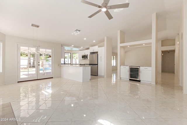 unfurnished living room with french doors, wine cooler, and ceiling fan