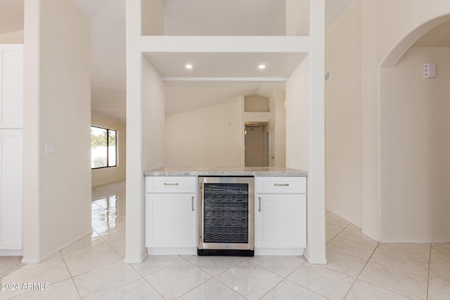 bar with white cabinets, light tile patterned floors, and wine cooler