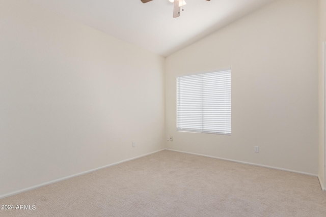 carpeted spare room featuring ceiling fan and lofted ceiling