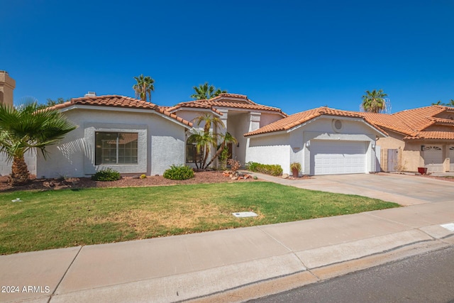 mediterranean / spanish-style home featuring a front yard and a garage