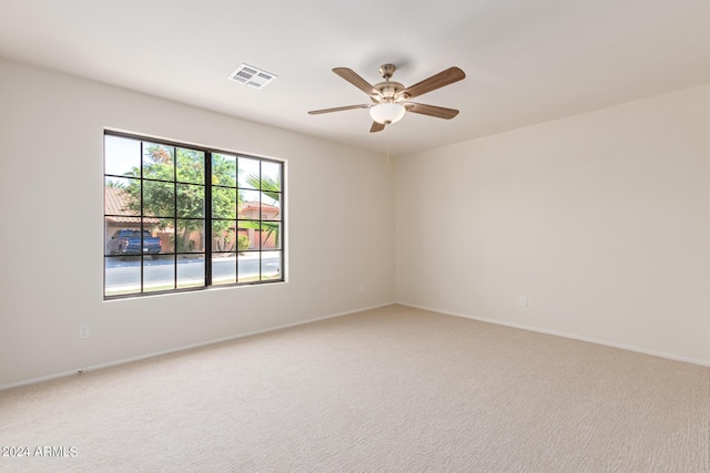 empty room featuring ceiling fan and carpet