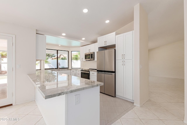 kitchen with stainless steel appliances, white cabinets, light stone counters, kitchen peninsula, and light tile patterned flooring