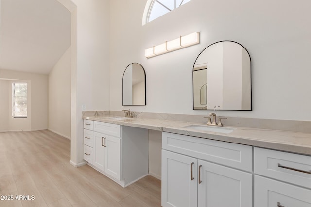 bathroom with vanity, wood-type flooring, and lofted ceiling