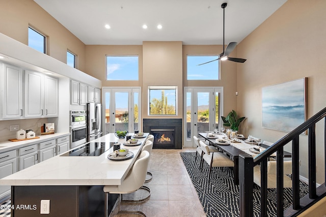 kitchen with a high ceiling, french doors, and plenty of natural light