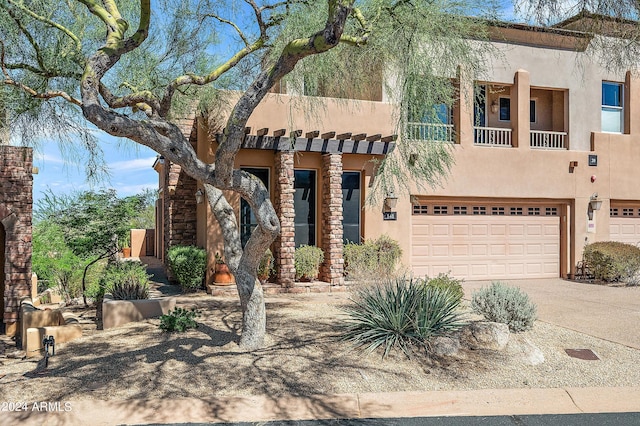 pueblo-style house featuring a garage