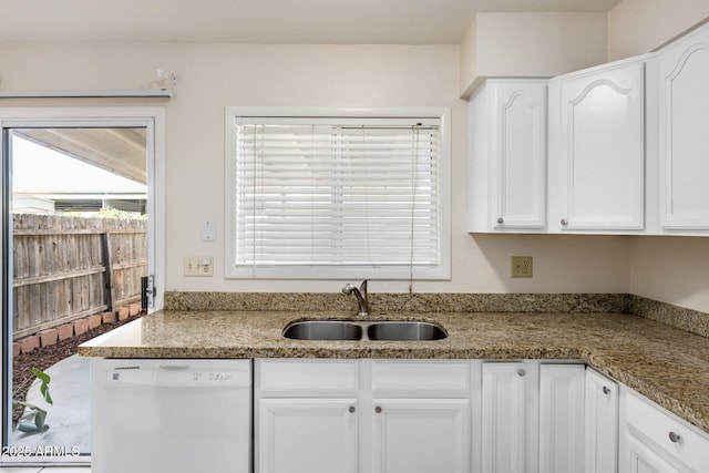 kitchen with white dishwasher, sink, white cabinetry, and light stone countertops