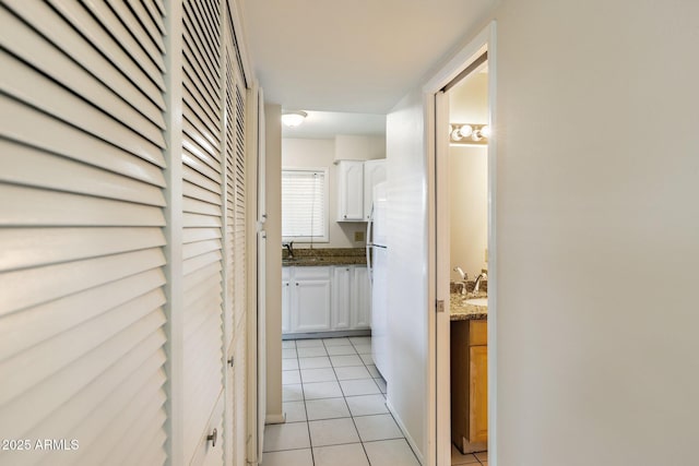 hallway featuring sink and light tile patterned floors