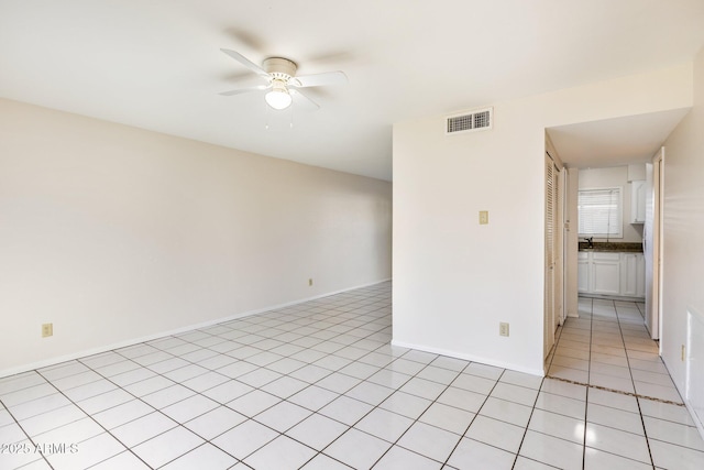 tiled empty room with ceiling fan