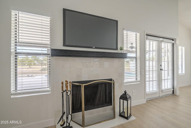 details featuring hardwood / wood-style flooring and a tile fireplace