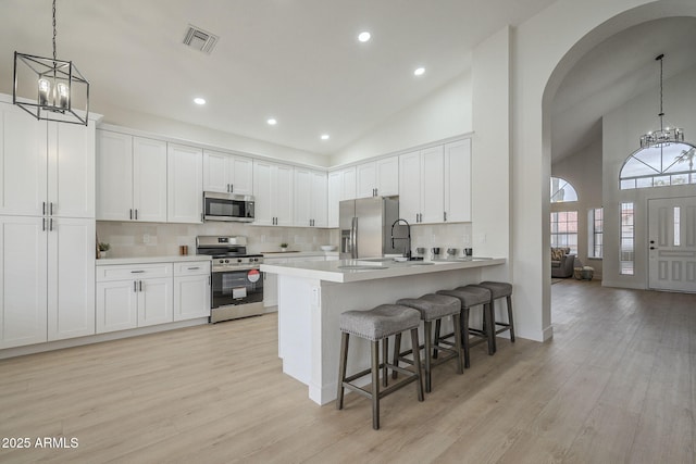 kitchen with white cabinetry, appliances with stainless steel finishes, and an inviting chandelier