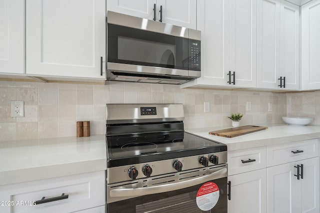 kitchen with tasteful backsplash, stainless steel appliances, and white cabinets