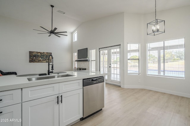 kitchen with sink, light hardwood / wood-style flooring, white cabinetry, decorative light fixtures, and stainless steel dishwasher