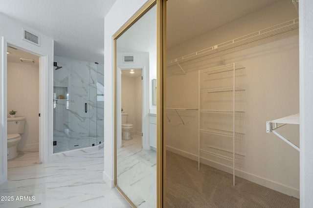 bathroom featuring walk in shower and toilet