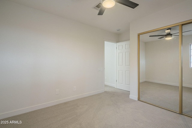 unfurnished bedroom with light colored carpet, ceiling fan, and a closet