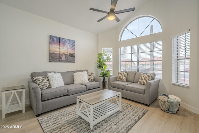 living room featuring ceiling fan, a wealth of natural light, and light wood-type flooring