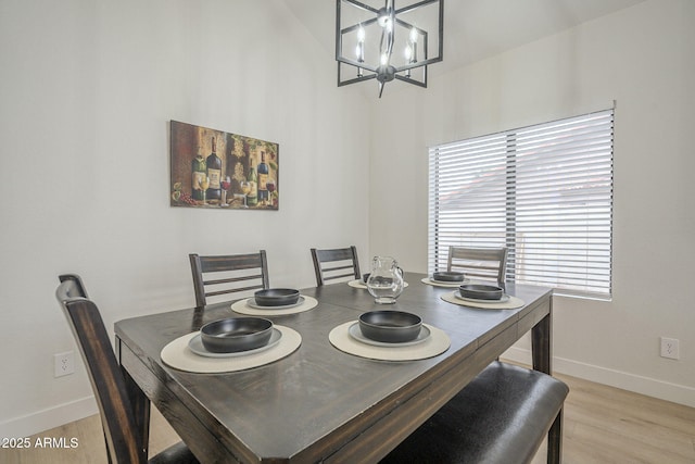 dining room with light wood-type flooring and a notable chandelier