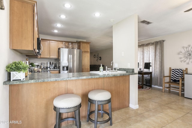 kitchen featuring appliances with stainless steel finishes, kitchen peninsula, sink, and light tile patterned floors