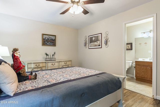 bedroom featuring light hardwood / wood-style flooring, ceiling fan, and ensuite bathroom