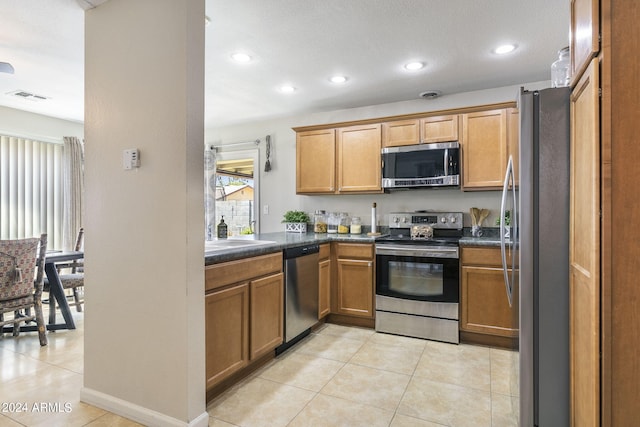 kitchen with light tile patterned floors, sink, and appliances with stainless steel finishes