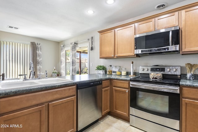 kitchen featuring sink, light tile patterned floors, and stainless steel appliances