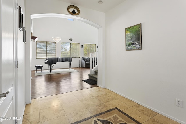 11959 W Vernon Ave, Avondale, AZ 85392 - hall featuring light tile patterned flooring, arched walkways, baseboards, and stairway