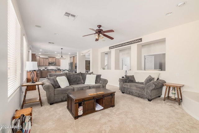 carpeted living room with ceiling fan