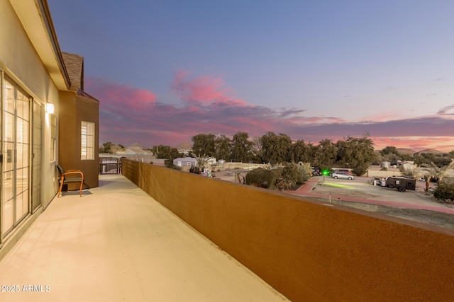 patio terrace at dusk featuring a balcony