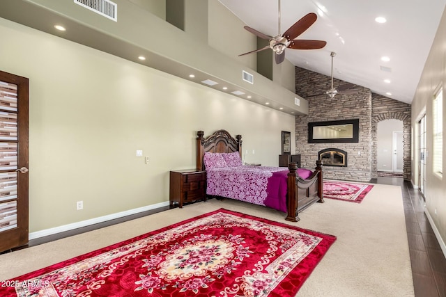 bedroom featuring a stone fireplace, ceiling fan, and high vaulted ceiling