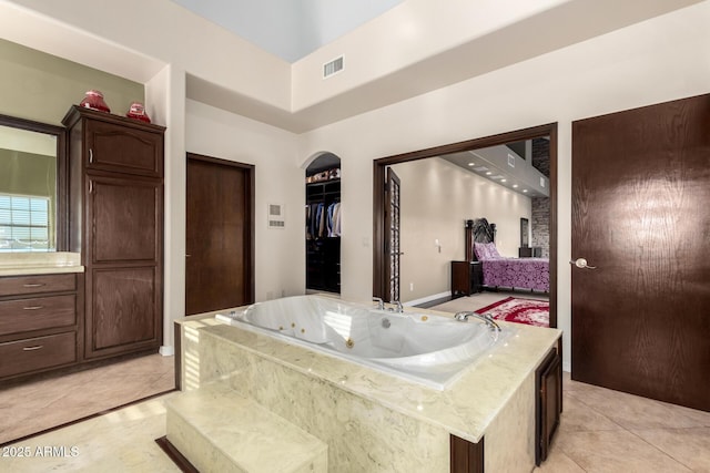 bathroom featuring tile patterned flooring and tiled bath