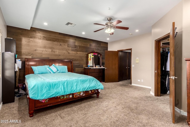 bedroom featuring carpet, wood walls, and ceiling fan