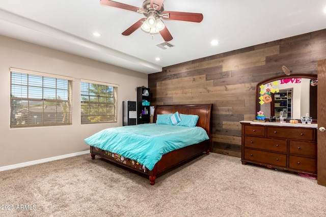 carpeted bedroom with ceiling fan and wooden walls