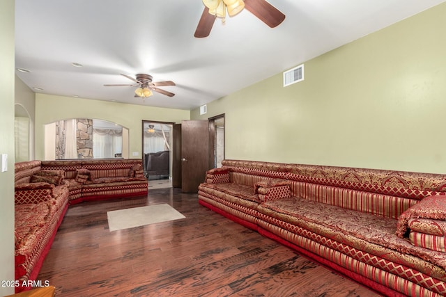 living room with dark hardwood / wood-style flooring and ceiling fan