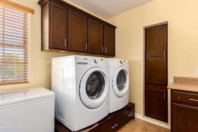 clothes washing area featuring cabinets, separate washer and dryer, and a wealth of natural light