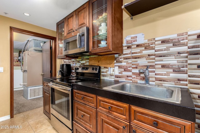 kitchen with backsplash, sink, stainless steel appliances, and light carpet