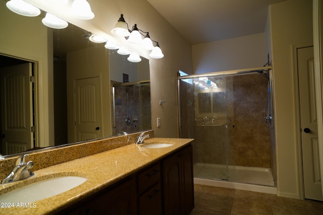 bathroom with a shower with shower door, tile patterned flooring, and dual bowl vanity