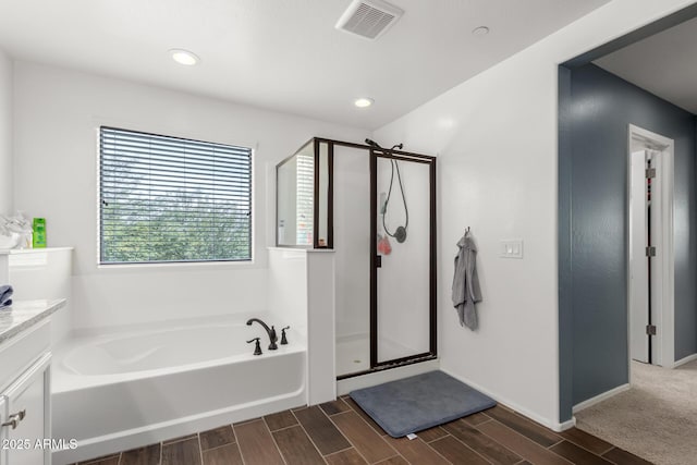 bathroom featuring vanity and independent shower and bath