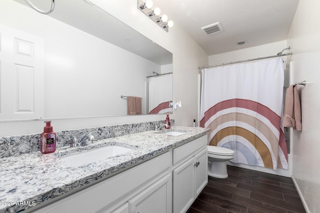 bathroom with a shower with shower curtain, vanity, and toilet