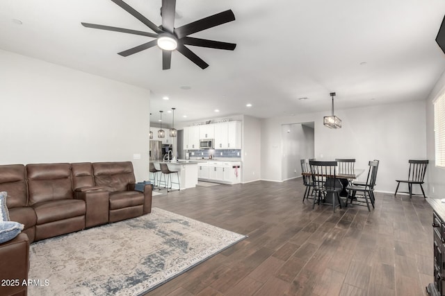 living room with ceiling fan and dark hardwood / wood-style floors