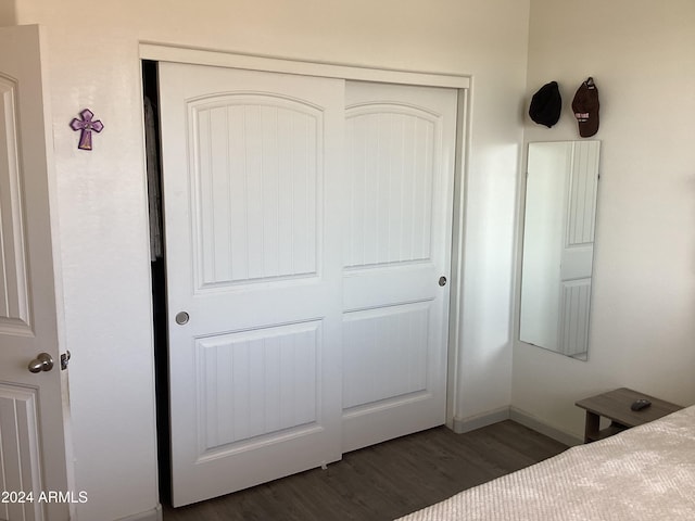 unfurnished bedroom with a closet and dark wood-type flooring