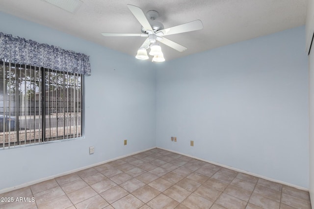 spare room featuring baseboards, visible vents, and ceiling fan