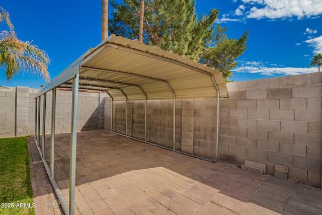 view of parking / parking lot with a detached carport and fence