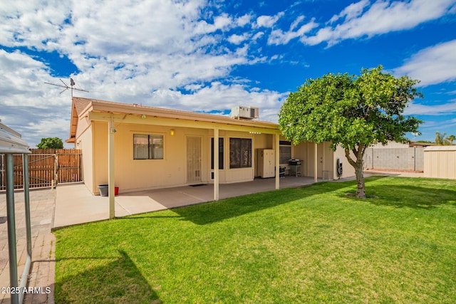 back of property featuring a patio area, central air condition unit, a yard, and fence