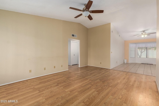 spare room with visible vents, lofted ceiling, light wood-style floors, and ceiling fan