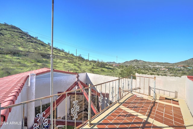 view of patio with a balcony and a mountain view