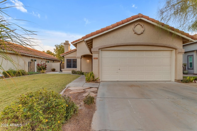 mediterranean / spanish home featuring a front lawn and a garage