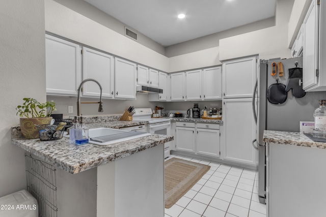 kitchen featuring light tile patterned flooring, white range with electric stovetop, kitchen peninsula, stainless steel fridge, and white cabinets