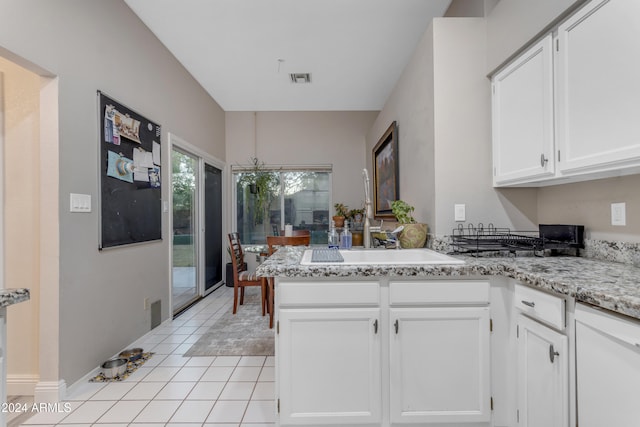 kitchen featuring kitchen peninsula, sink, white cabinets, and light tile patterned flooring